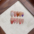 Handmade pink flower press-on nails by Glitify in various designs.