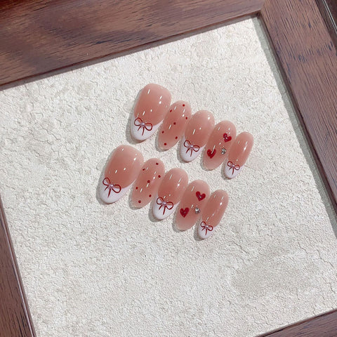 Nail art featuring ballet shoe design with red bows and hearts.