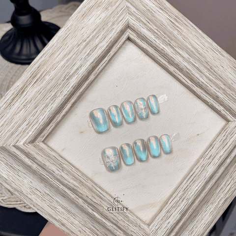 Galaxy Blue handmade press-on nails displayed in a decorative frame.